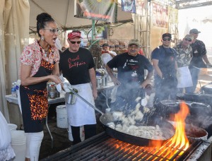 Chef Carla Hall learns how to do a calamari flame-up on Gourmet Alley at the 2014 festival